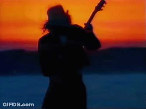 Silhouette Of Man Playing Guitar At Sunset GIF