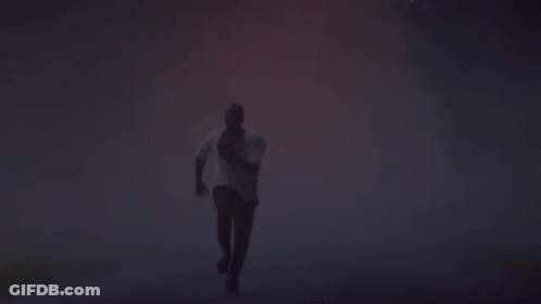 Silhouette Of Man Running In Foggy Forest GIF