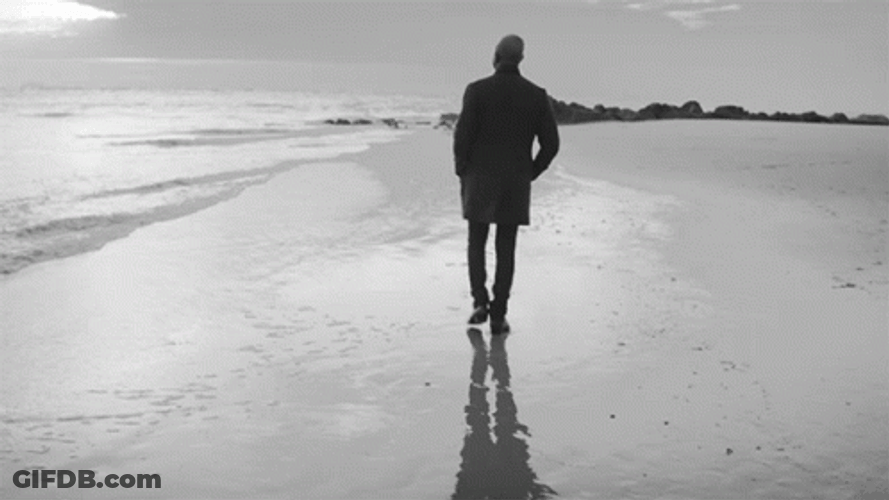 Silhouette Of Man Walking Away On Beach GIF
