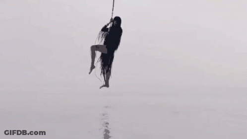 Silhouette Of Woman Hanging From Rope In Sky GIF