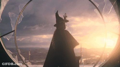 Silhouette Of Woman In Witch Hat Looking Out Window GIF