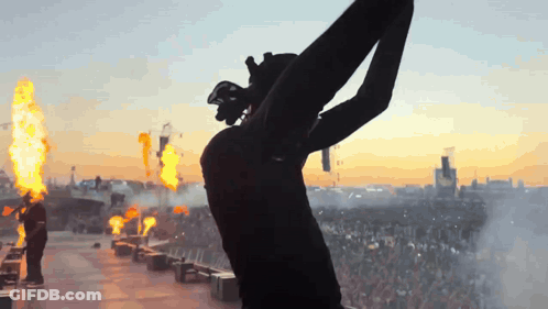 Silhouette Person Arms Outstretched In Flames GIF