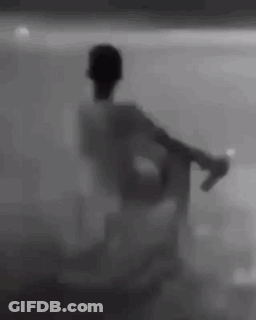 Silhouette Sitting In Chair Behind Glass Wall GIF