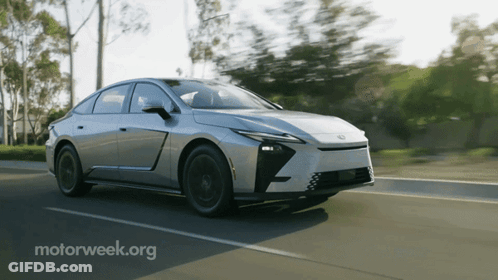 Silver Car Driving Down Road With Motorweek.org GIF
