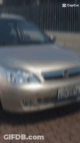 Silver Car Parked In Front Of Fence With Capcut GIF