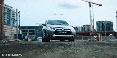 Silver Mitsubishi Driving Down Gravel Road GIF