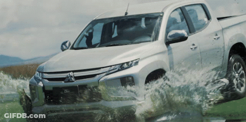 Silver Mitsubishi Truck Driving Through Puddle GIF
