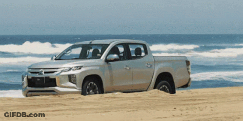 Silver Mitsubishi Truck On Sandy Beach GIF