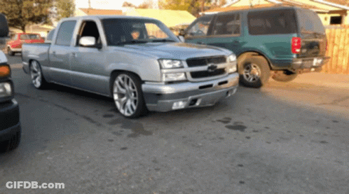 Silver Pickup Truck Next To Green Van GIF