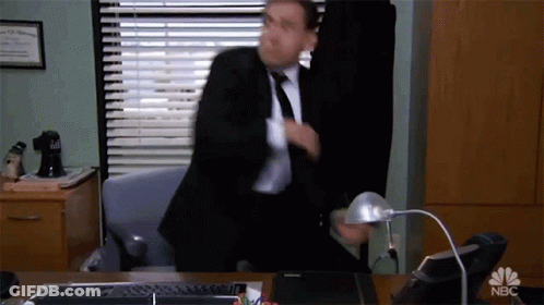 Sitting Man In Suit And Tie At NBC Sign GIF