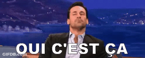 Sitting Man In Suit With Oui C'est Ca Sign GIF