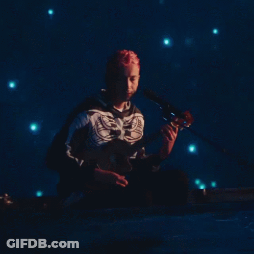 Skeleton Shirt Man Plays Guitar In Dark Room GIF