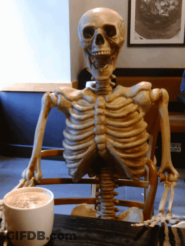 Skeleton Sitting At Table With Coffee GIF
