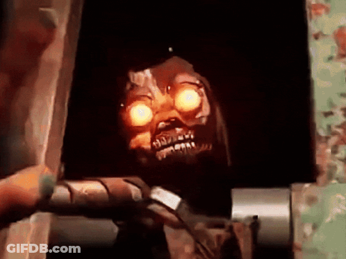 Skeleton With Glowing Eyes In Dark Room GIF