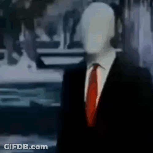 Slender Man In Suit And Tie Standing In Room GIF