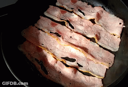Slices Of Bacon Are Cooking In A Skillet GIF
