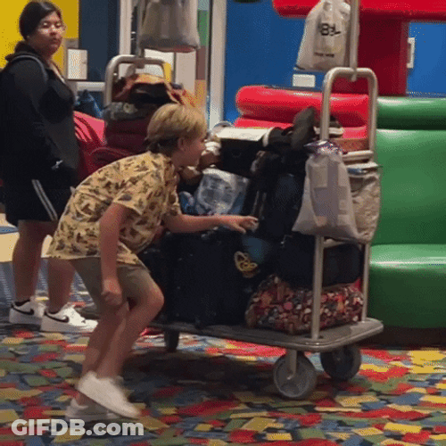 Sly Young Boy Hiding Behind Luggage GIF