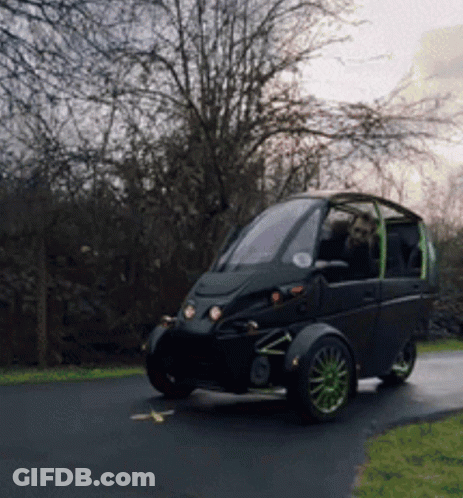Small Black Car With Green Wheels Parked On Road GIF