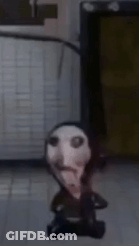Small Doll With Bloody Face Sitting On Floor GIF