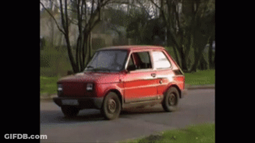 Small Red Car Driving Down Road GIF