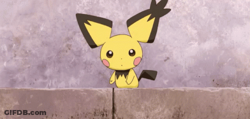 Small Yellow And Black Cartoon Sitting On Brick Wall GIF
