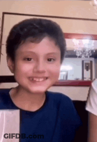 Smiling Boy Looking At Camera In Living Room GIF