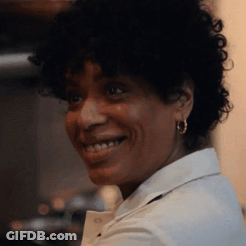 Smiling Curly Hair Woman In White Shirt And Hoop Earrings GIF