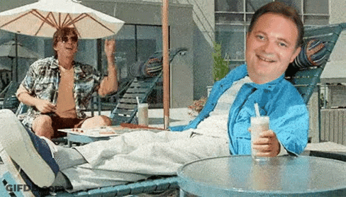 Smiling Man Holding Drink, Man Standing Behind GIF