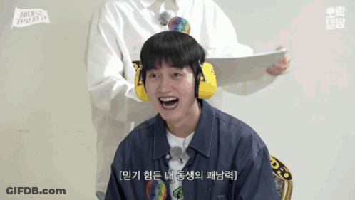 Smiling Man In Ear Muffs And Man Holding Paper GIF