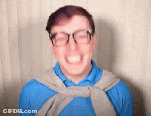 Smiling Man In Glasses, Blue Shirt, And Gray Sweater GIF