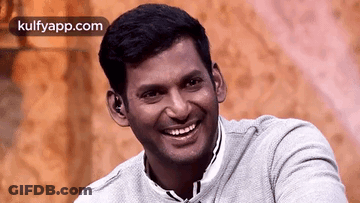 Smiling Man In Gray Sweater Sitting GIF