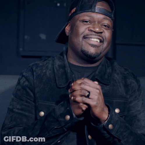 Smiling Man In Hat With Ring Holding Something GIF