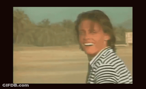 Smiling Man In Striped Shirt In Desert GIF