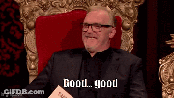 Smiling Man In Suit And Glasses Holding Book Saying Good GIF