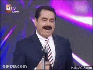 Smiling Man In Suit And Tie Holding Microphone GIF