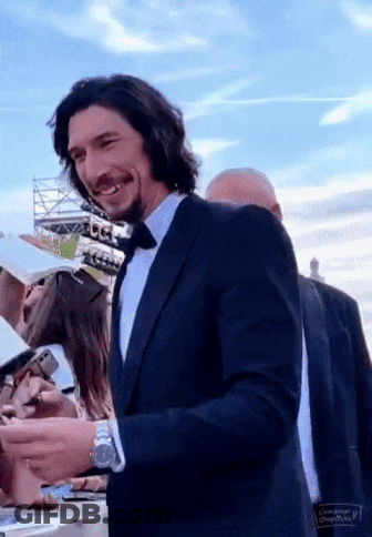 Smiling Man In Suit And Tie Signing Autographs GIF