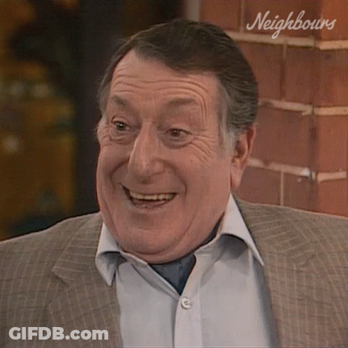 Smiling Man In Suit By Neighbours Brick Wall GIF