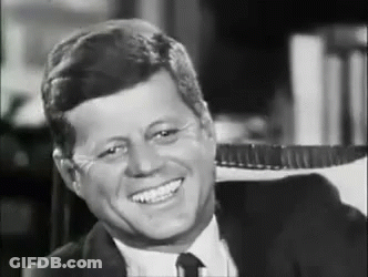 Smiling Man In Suit Sitting In Chair GIF