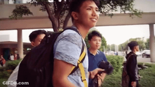Smiling Man With Backpack Walking With Two Men GIF