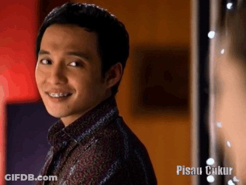 Smiling Man With Braces In Front Of Pisau Cukup Sign GIF