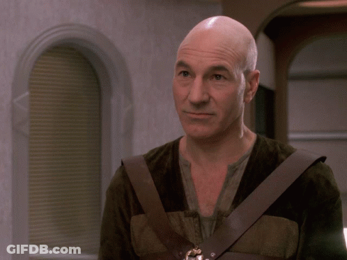 Smiling Man With Shaved Head And Brown Vest GIF