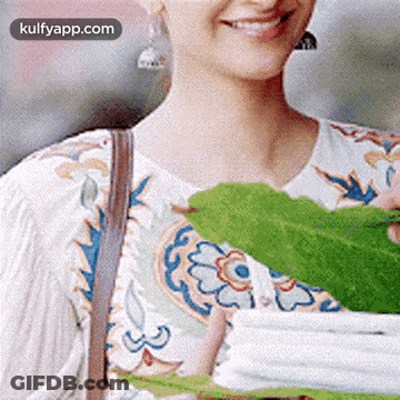 Smiling Woman Holding Green Leaf GIF