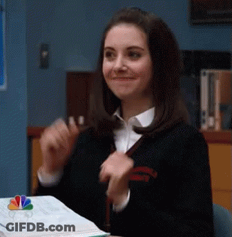 Smiling Woman Sitting At Desk With Book GIF