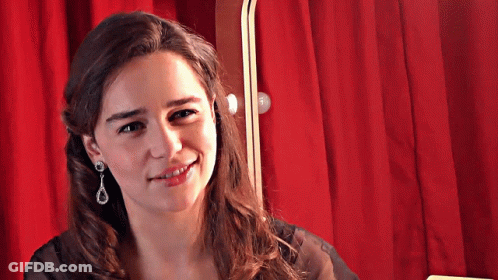 Smiling Woman With Earrings And Red Curtain GIF