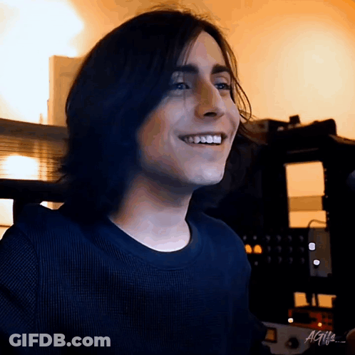 Smiling Young Man With Long Hair And Black Shirt GIF