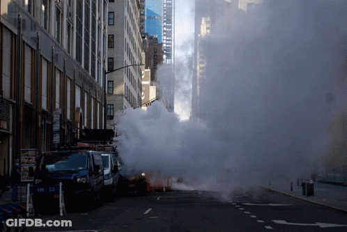 Smoke Is Coming Out Of A Drain On The Side Of The Road GIF