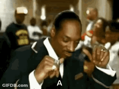 Snoop Dogg In Suit Holding Microphone In Crowd GIF
