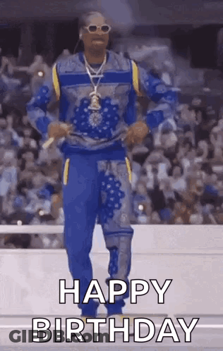 Snoop Dogg Is Dancing In Front Of A Crowd While Wearing A Blue And Yellow Outfit . GIF