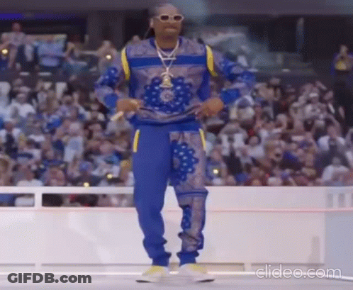 Snoop Dogg Is Dancing On A Stage In Front Of A Crowd At A Basketball Game . GIF