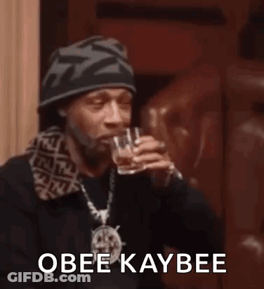Snoop Dogg Is Drinking From A Glass While Wearing A Hat . GIF